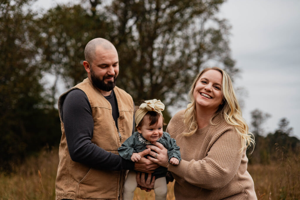 Parents interacting with baby during milestone family photo session
