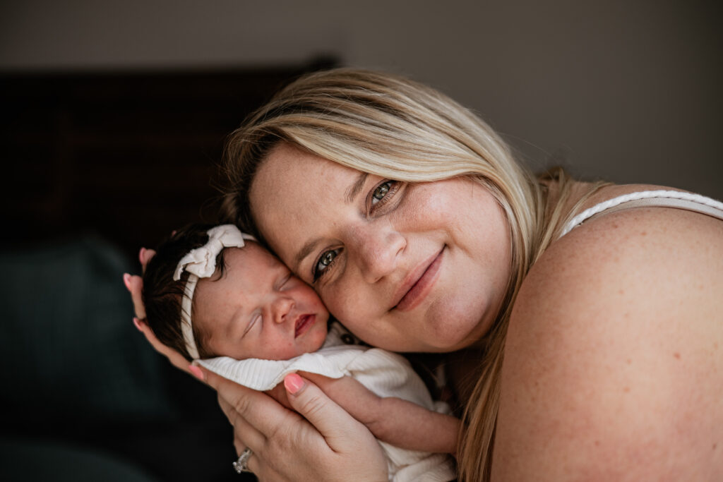 Mom cuddling newborn in natural light family photography