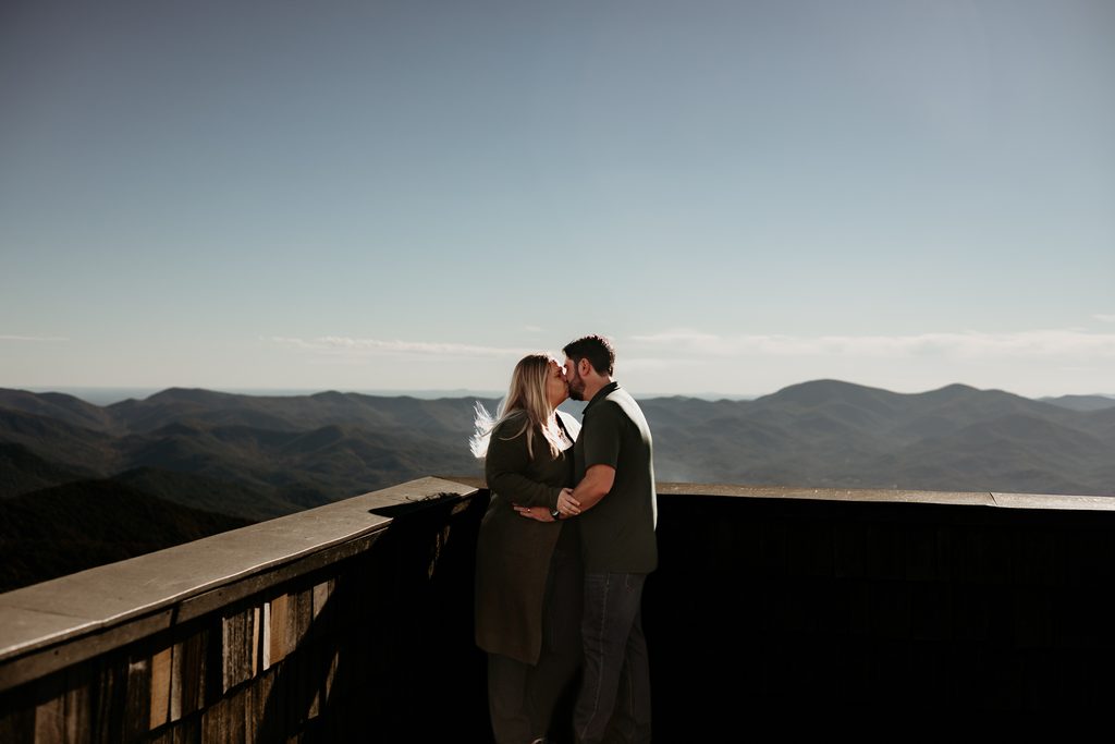 Couple kissing at a scenic North Georgia mountain overlook during fall vacation