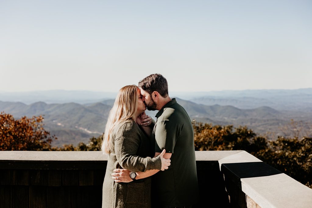 Wide view of a couple on a rustic mountain observation deck in North Georgia